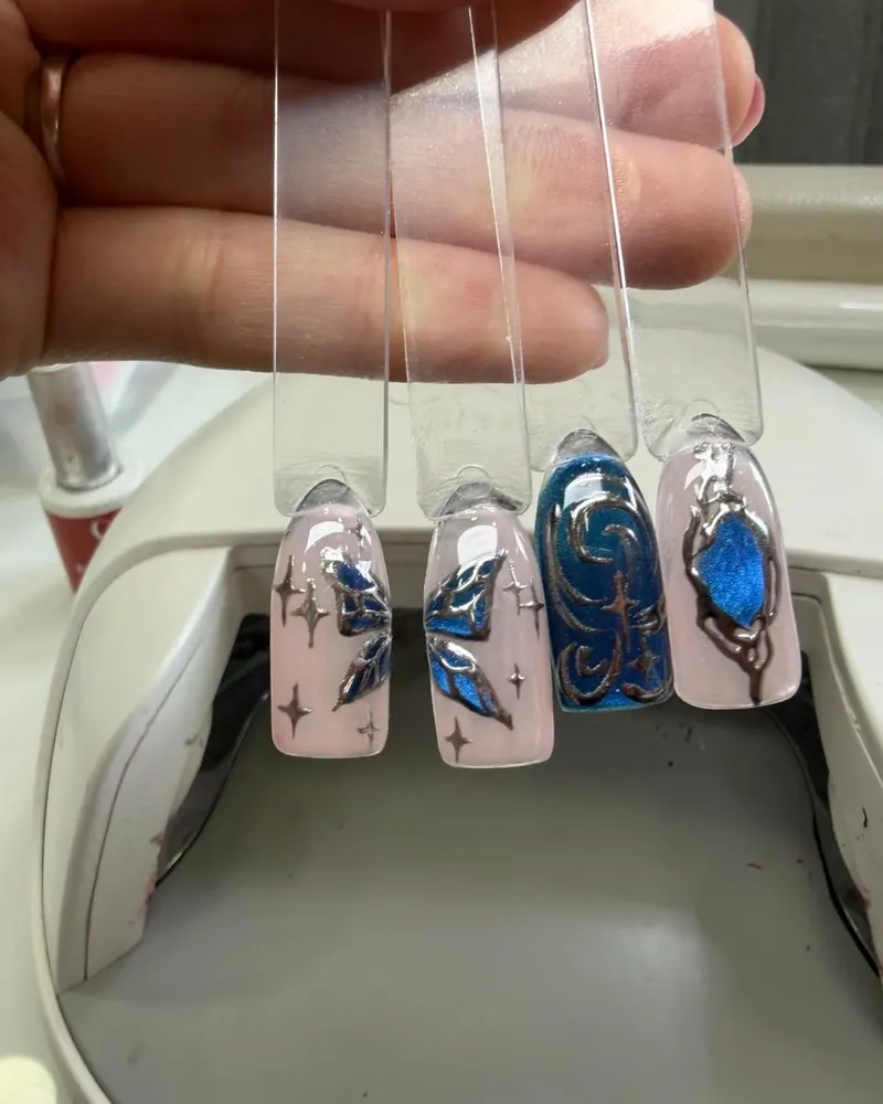 Hand-painted nail art samples in blue and silver